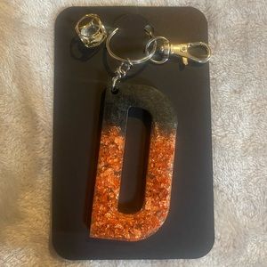 Handmade letter D resin keychain. Black and gold
